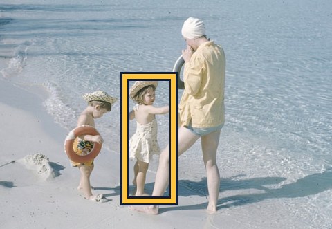 Child at the beach with face hidden under a sun hat, outlined in gold.