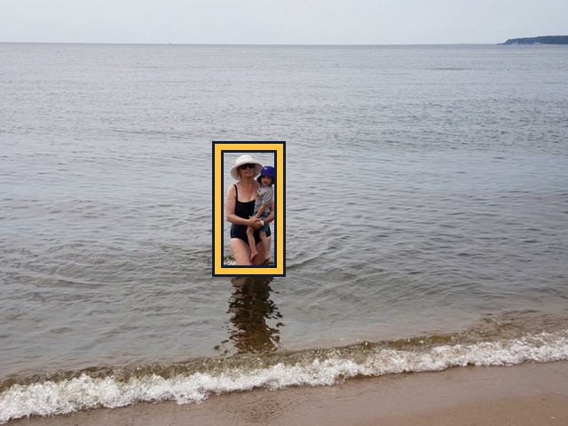 A woman wading at the beach in a hat and sunglasses; part of her face is visible.
